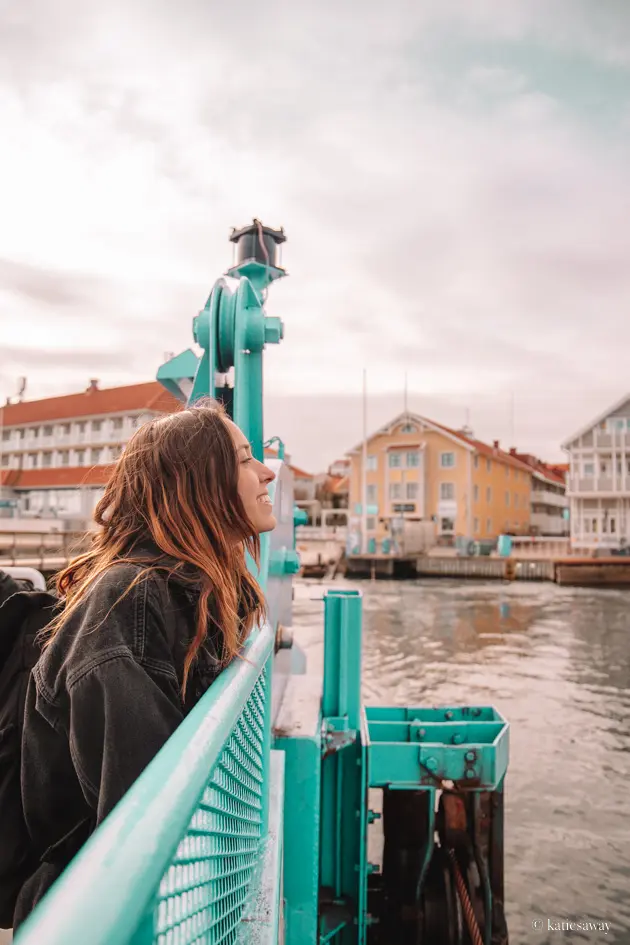 girl in a black jacket on the ferry with marstrand in the background