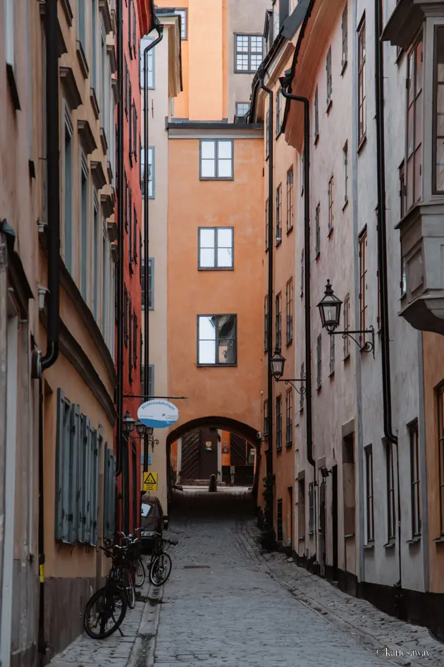 An alleyway leading into Stockholm's Gamla Stan with orange and yellow buildings on either side
