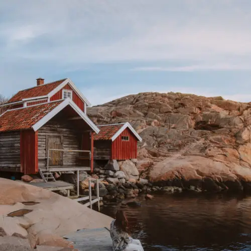 A collection of red boat houses part of the Vikarvet Culture Reserve